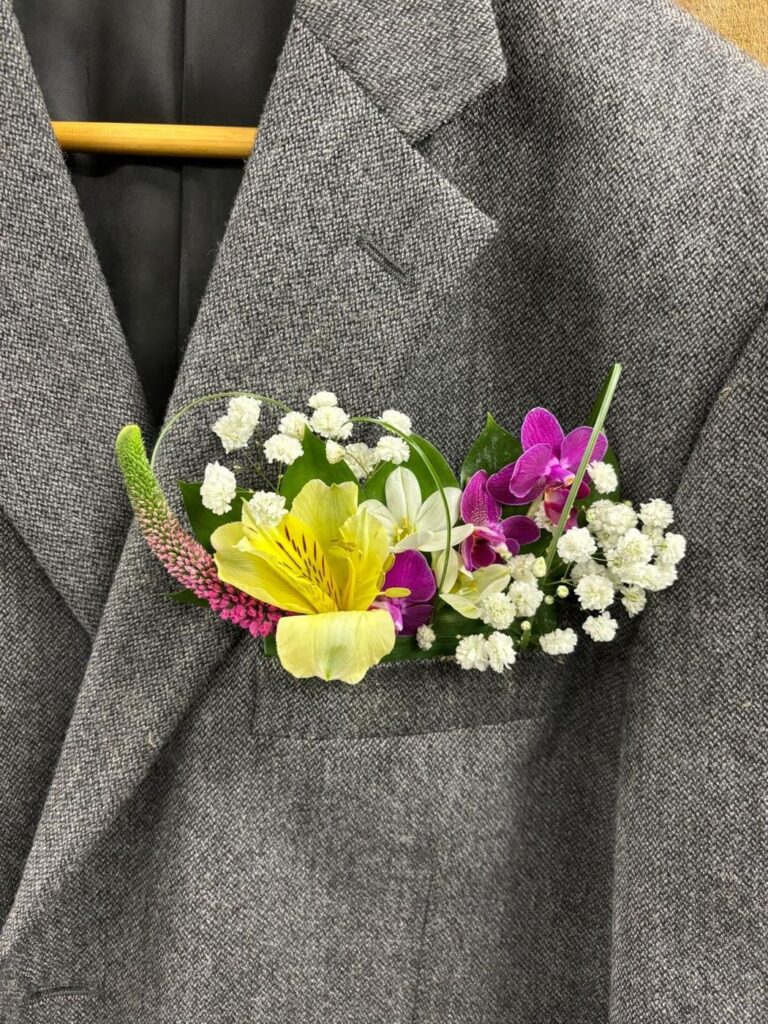 Pocket floral of yellow alstroemeria, mini orchids and baby’s breath