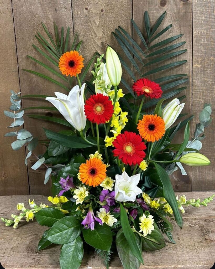 Lilies and orange gerberas fanned with palm