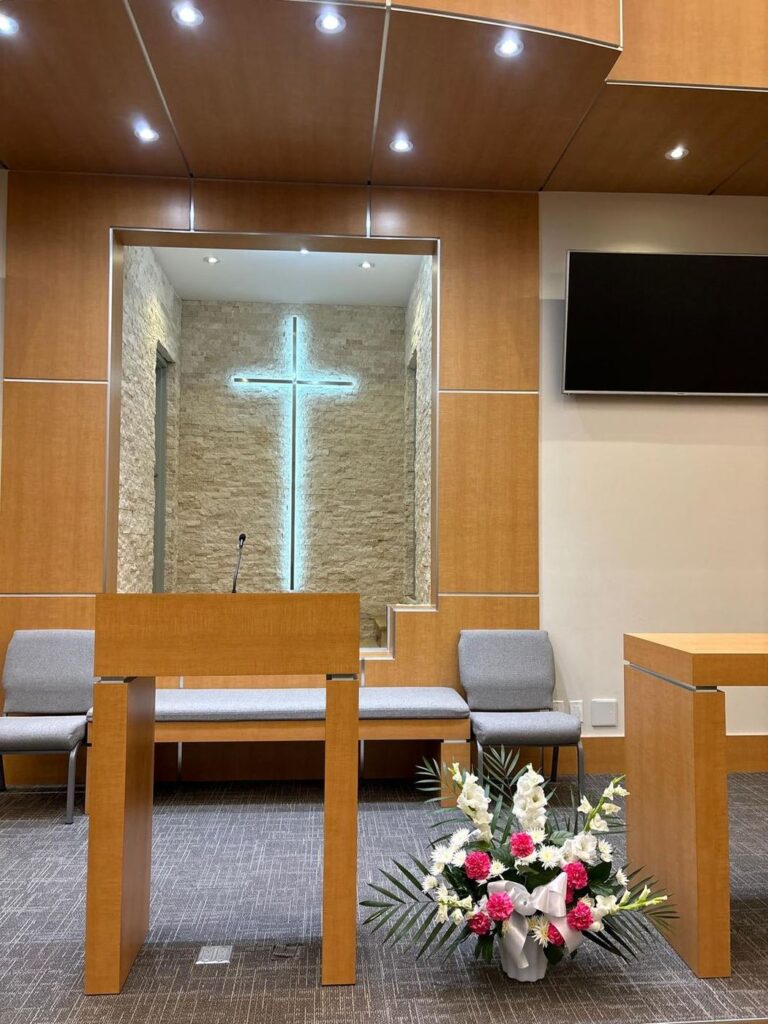 A white and pink arrangement with gladiolus and carnations, set up beside the lectern in a Toronto chapel